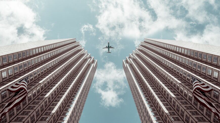 Vliegtuig dat boven symmetrische gebouwen vliegt