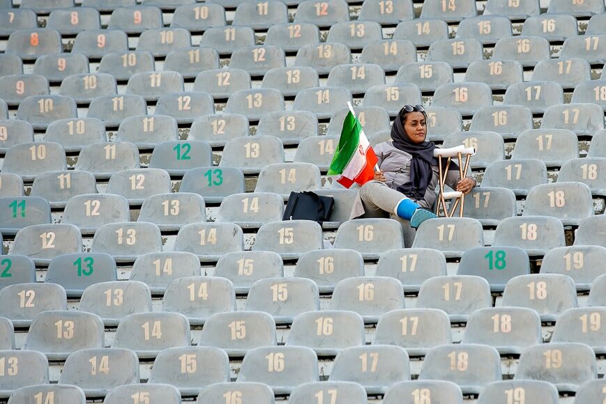 Vrouw die op lege tribunes in een stadion zit