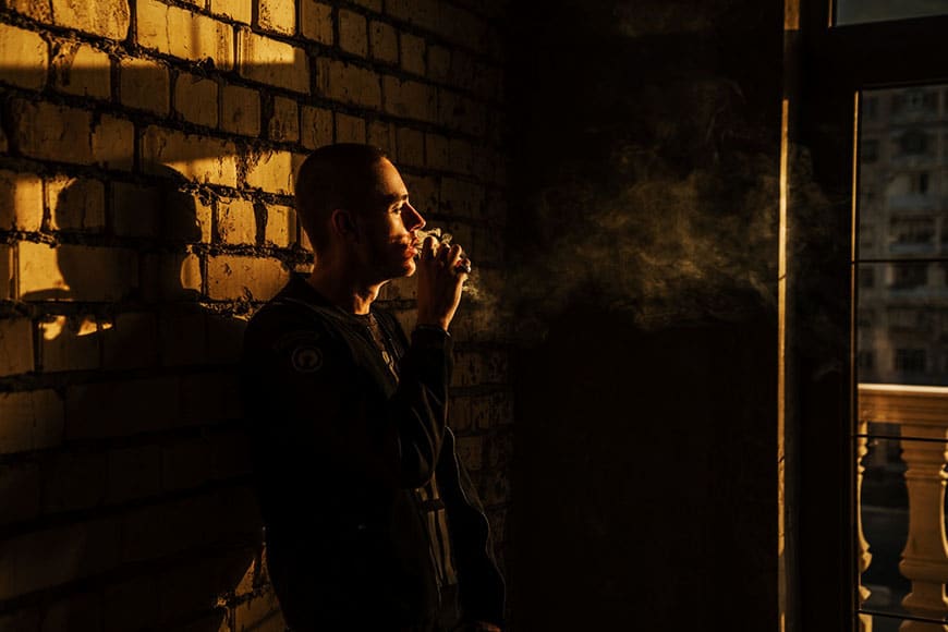 Foto van een man die rookt in stemmig licht