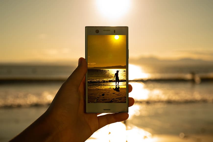 Afbeelding van een persoon op het strand vastgelegd op smartphone