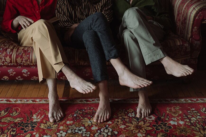 Gezichtsloos portret van de benen en voeten van drie mensen