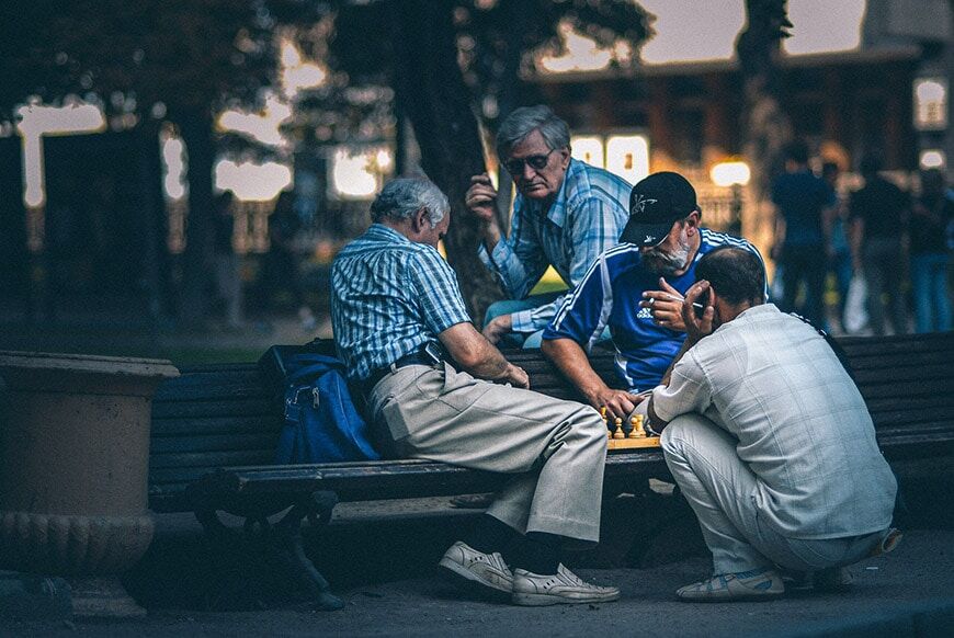 Fotografie bij weinig licht van oudere mannen die schaken in het park