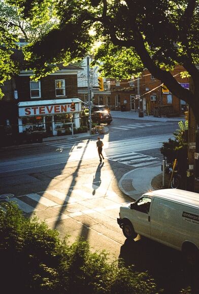 Stadsfotografie - man die over de weg naar een winkel rent