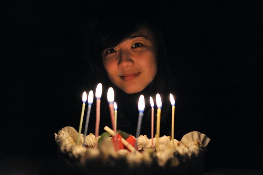 Meisje dat verjaardagstaart met kaarsen vasthoudt