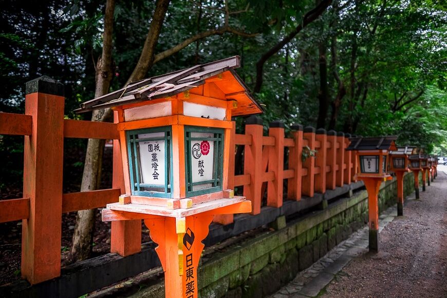 Een oranje hek omzoomd met Japanse brievenbussen 
