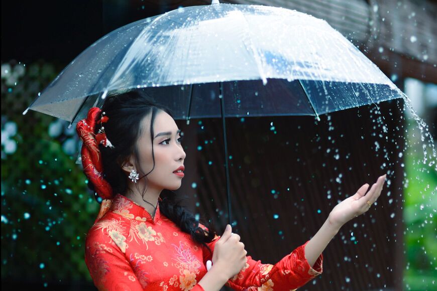 Vrouwen in het rood die onder een paraplu staan