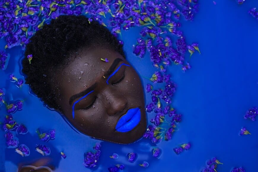 Modellen hoofd ondergedompeld in een gekleurd melkbad
