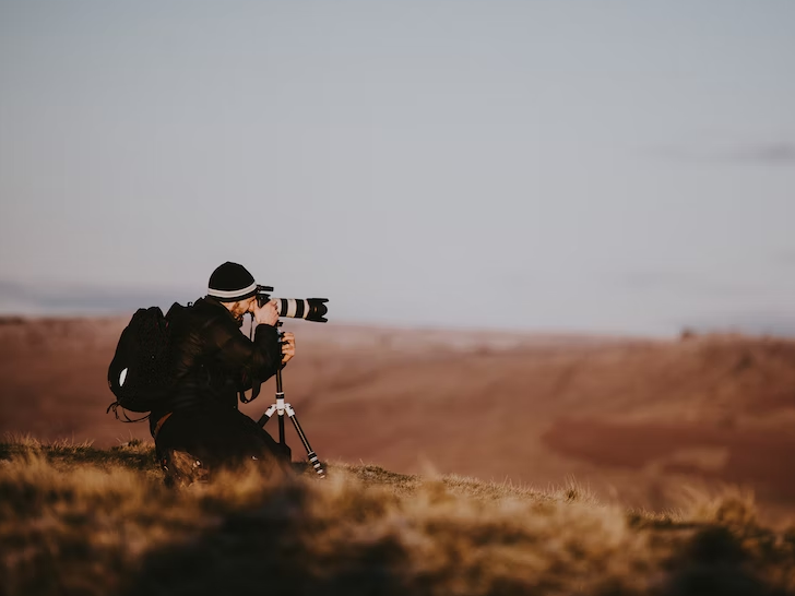 photographer holding camera in field