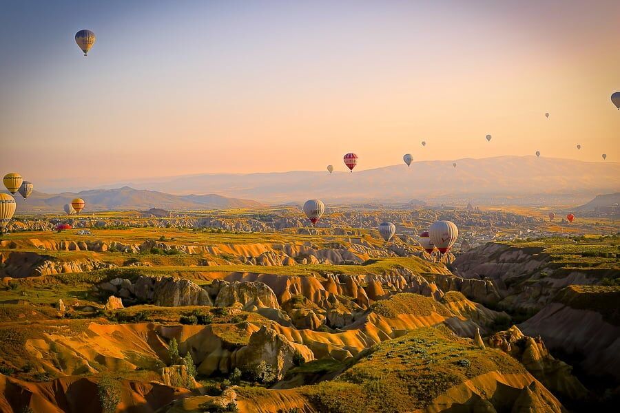 wat is vignetten - voorbeeldfoto van luchtballonnen boven een vallei.